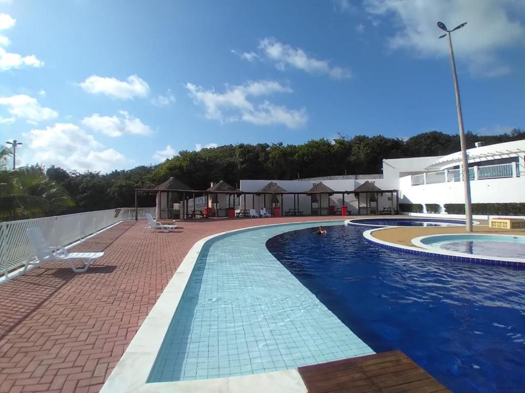 a large swimming pool next to a building at Condomínio encantador próximo a praia , 3 quartos. in João Pessoa