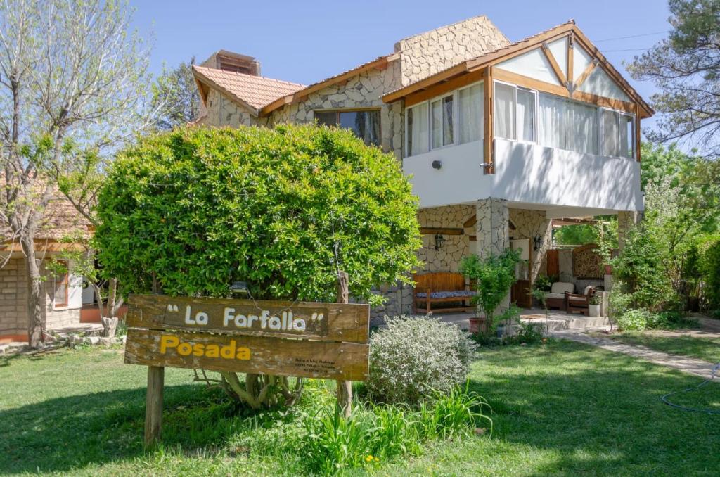 a house with a sign in front of it at Hosteria La Farfalla in Chos Malal