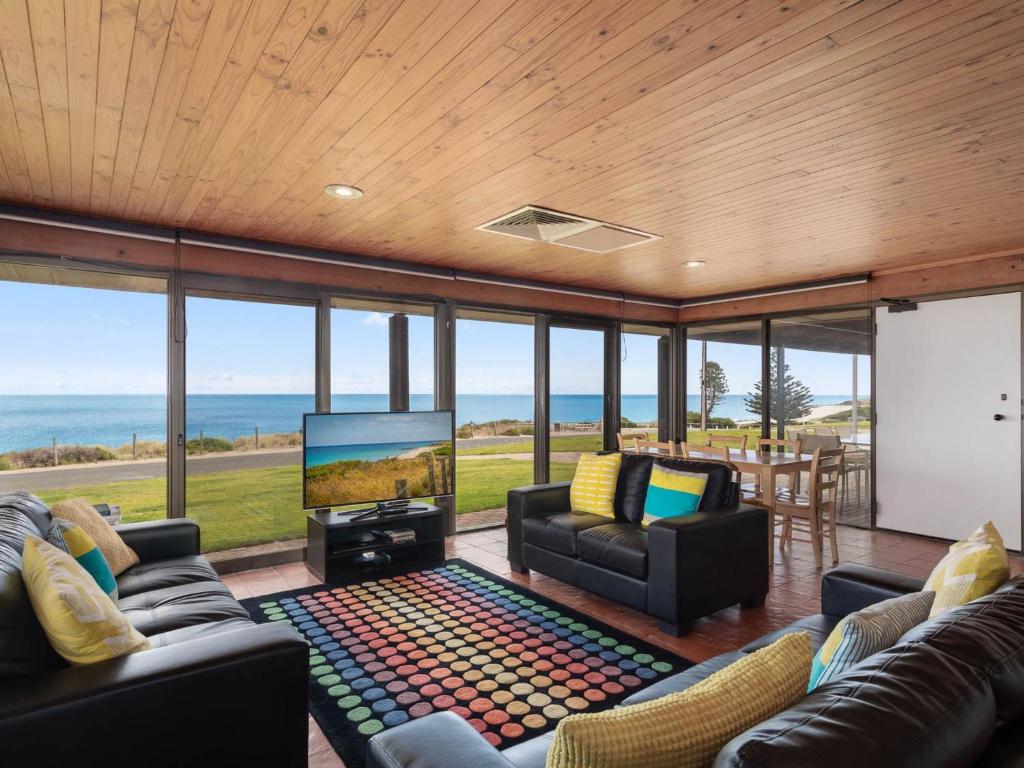 a living room with couches and a flat screen tv at Gold Coast Views 10 Gold Coast Drive in Normanville