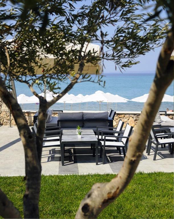 a group of picnic tables and umbrellas on the beach at Ostria Sea Side Hotel in Hanioti