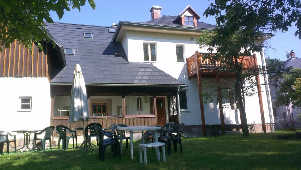 a house with a table and chairs in the yard at Holiday House Malá Skála in Malá Skála