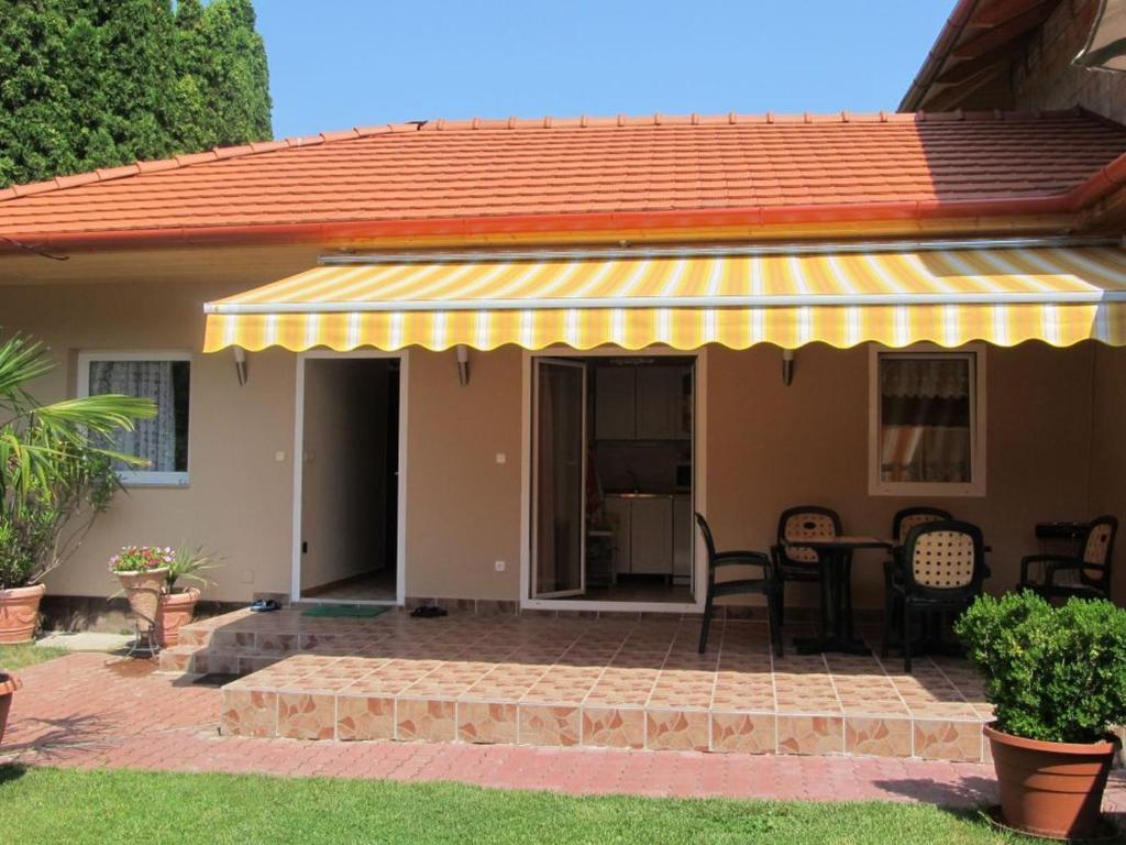 a house with a patio with a yellow awning at Szetti Nyaraló in Balatonszárszó