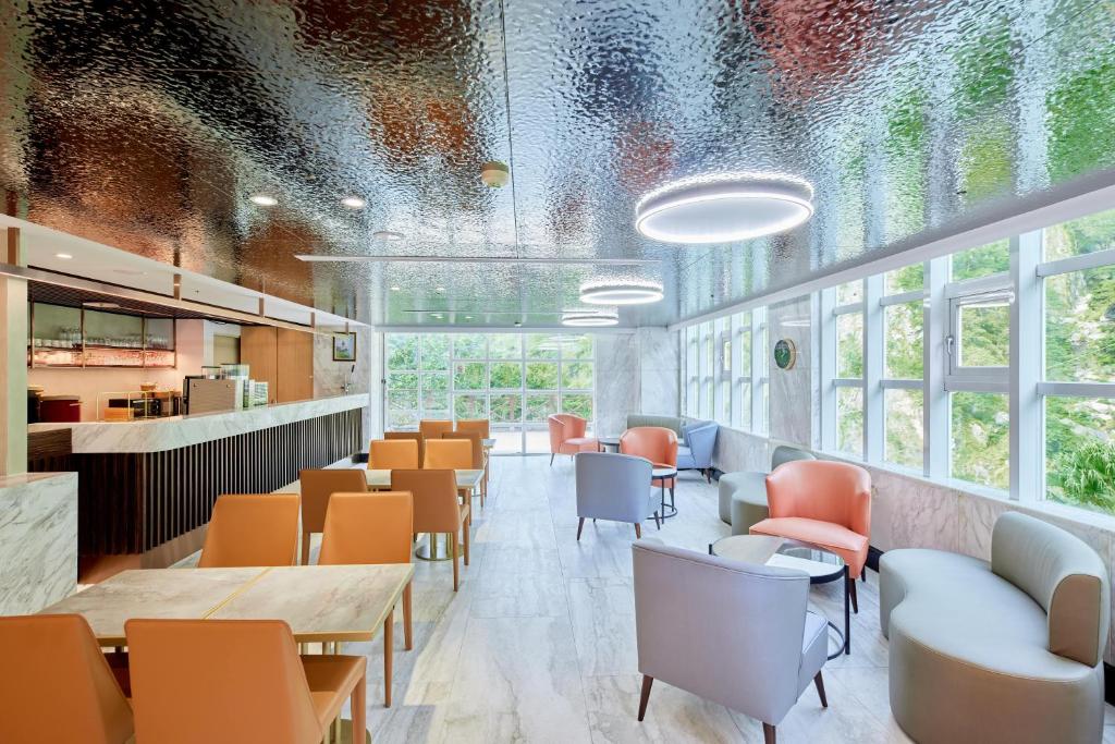 a restaurant with orange chairs and tables and windows at Uni-Resort Ku-Kuan in Heping