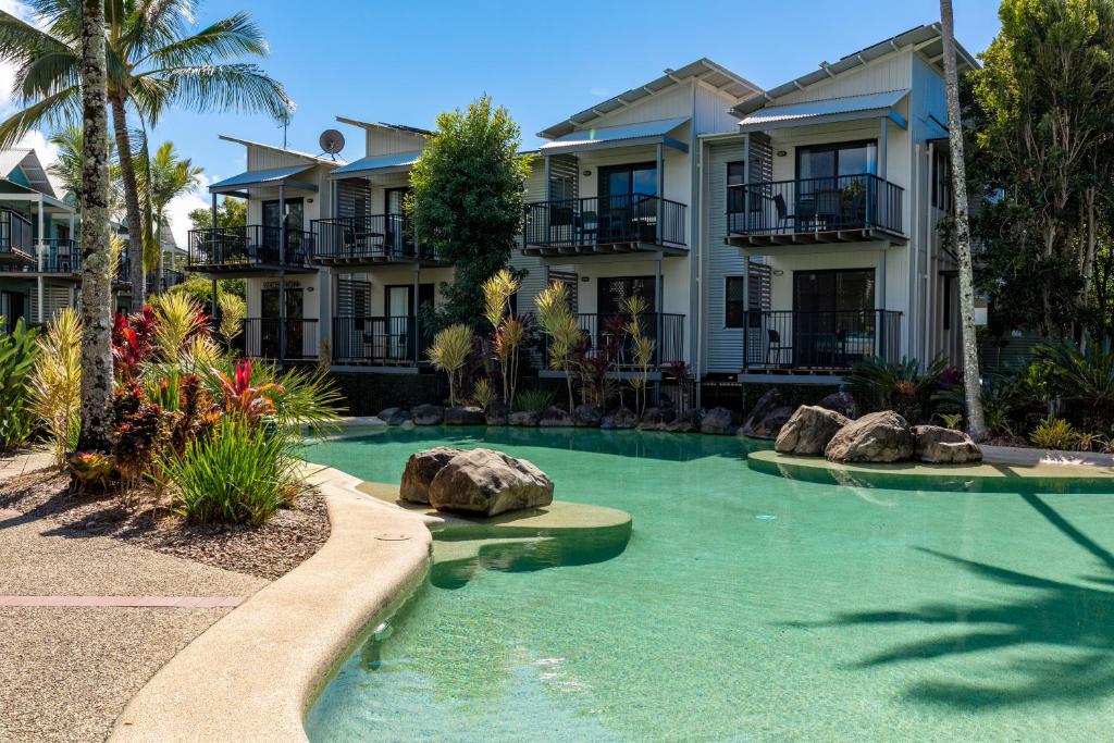 a resort with a swimming pool in front of a building at Noosa Lakes Resort in Noosaville