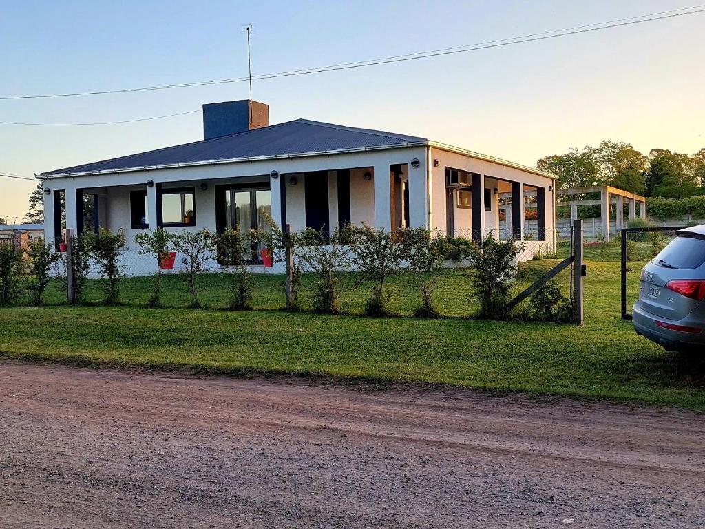 una casa con un coche aparcado delante de ella en La Casona de Lola en Tandil