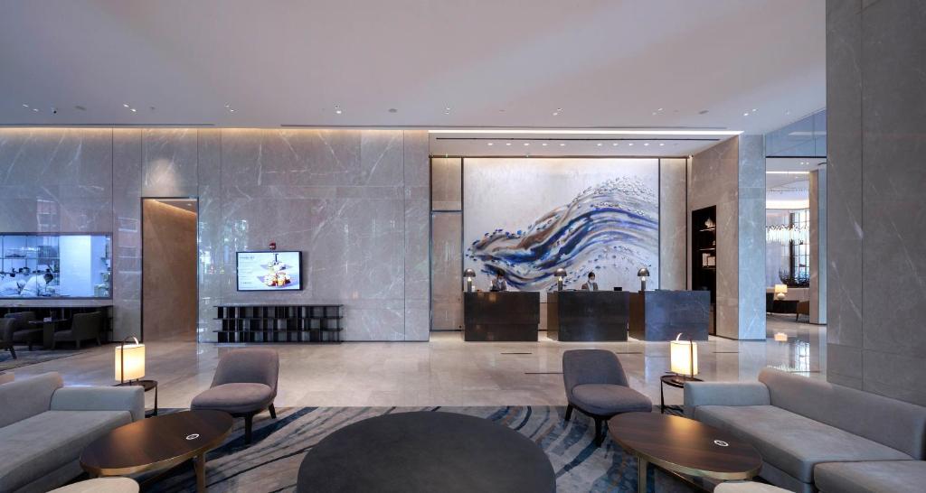 A polished lobby lounge facing a reception desk and large abstract artwork.