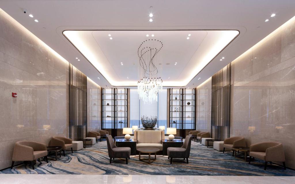 A formal lobby salon centered on a sculptural chandelier and lounge seating.