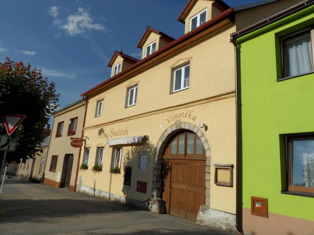 a building with a green and yellow building at Penzion Skalíček in Kunžak