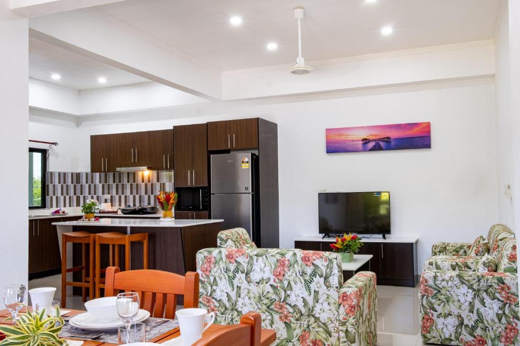 a kitchen and living room with a table and chairs at Coastal Suites Fiji in Sigatoka