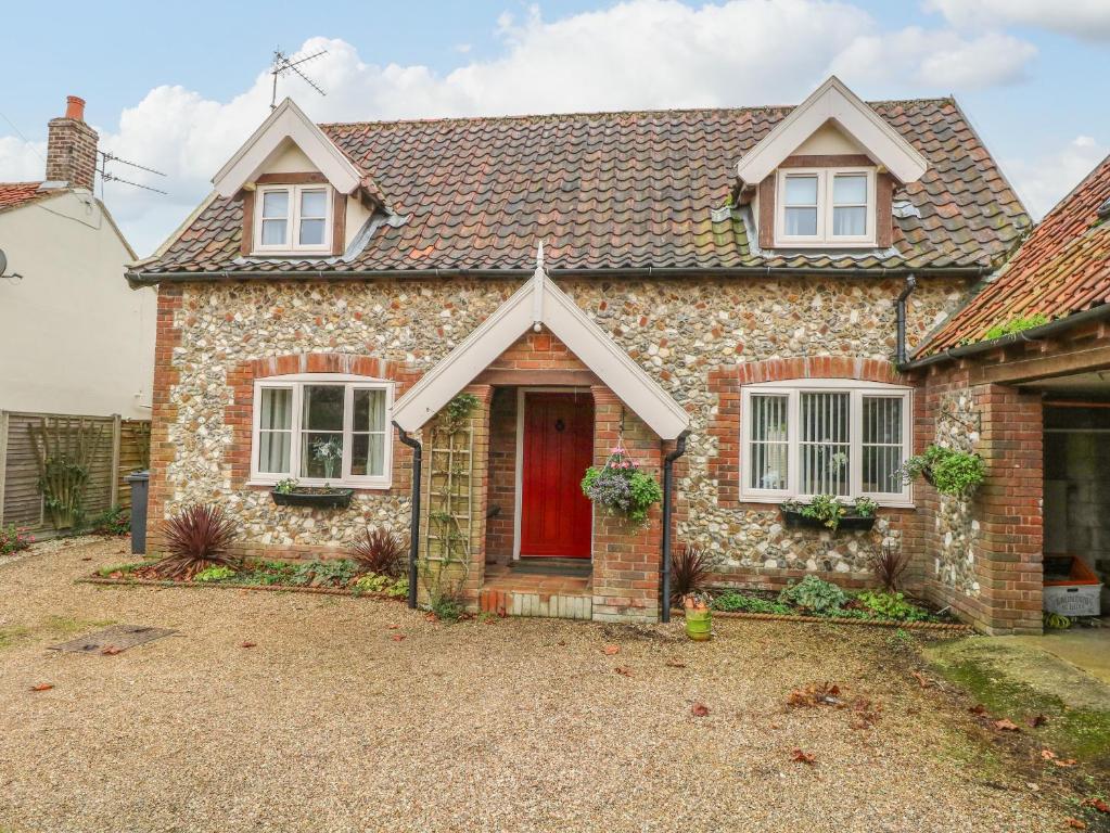 a stone house with a red door at Sleepeezy in Kettlestone