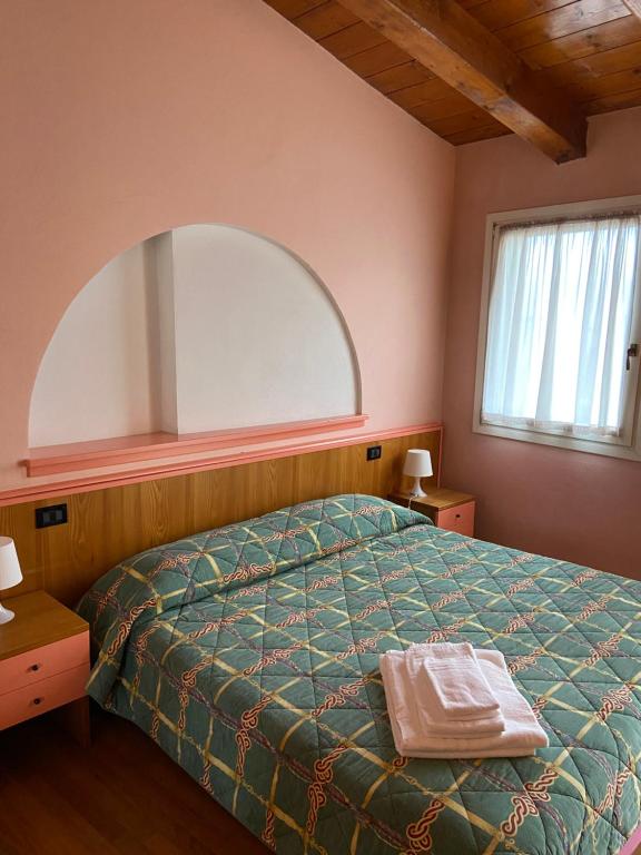 ヴィディチアティコにあるHotel La Piazzettaのベッドルーム(ベッド1台、大きな鏡付)