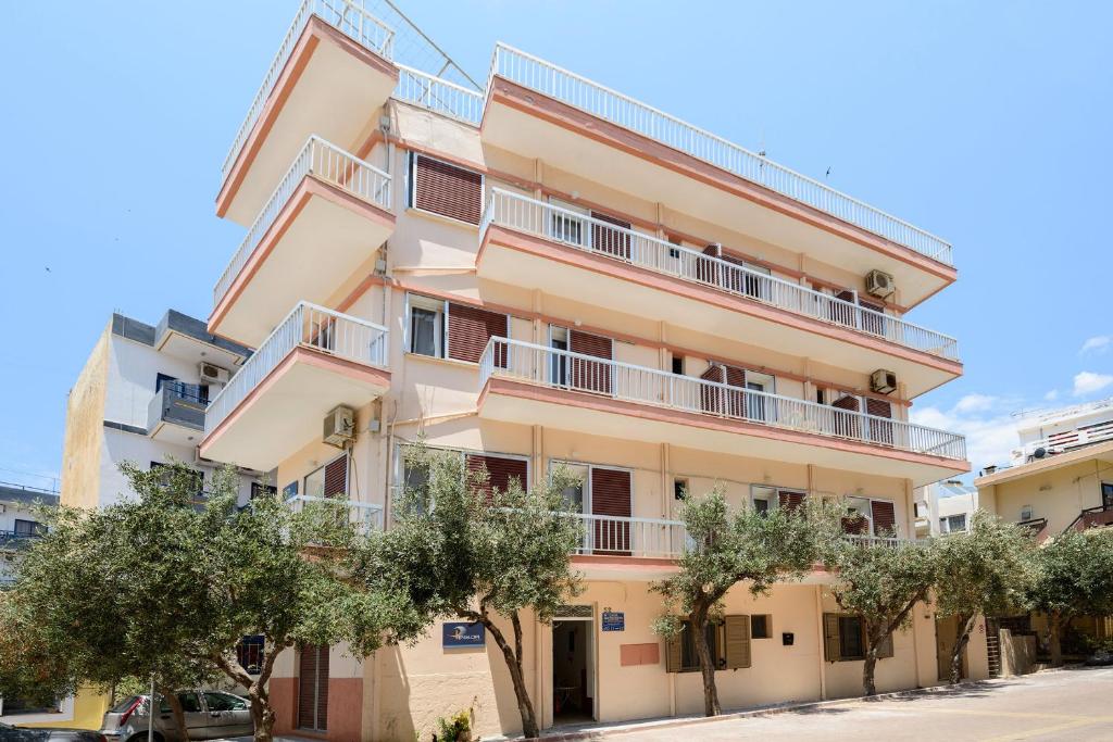 an apartment building with trees in front of it at Penelopi Rooms in Chania Town