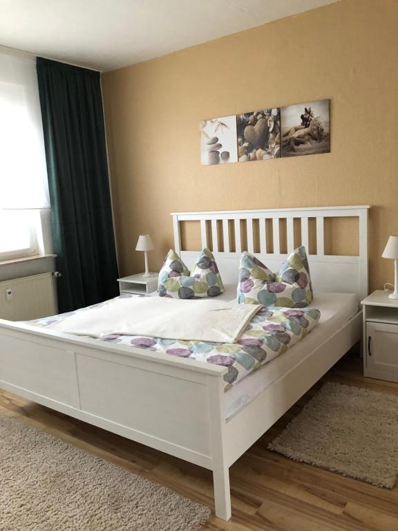 1 dormitorio con 1 cama blanca y 2 almohadas en Ferienwohnungen Heideblick, en Gräfenhainichen