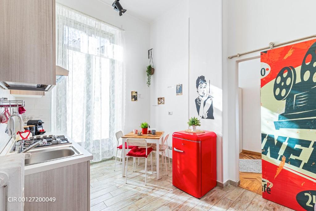 トリノにあるAppartamento Via Poのキッチン(赤い冷蔵庫、テーブル付)