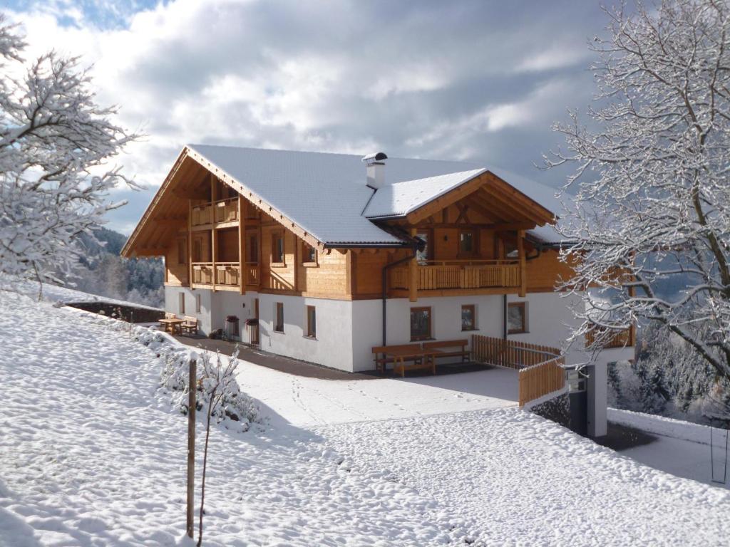 una gran casa de madera en la nieve en Thalerhof Appartement Verena, en Verano