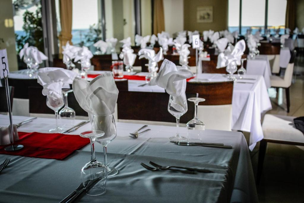 a row of tables with wine glasses and napkins at Konstantinos Palace in Karpathos