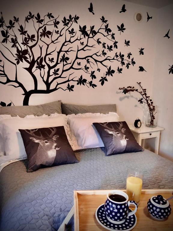 a bedroom with a bed with a tree with birds on it at Jodła i Modrzew Apartament przy Parku i Termach w centrum Uzdrowiska in Jelenia Góra