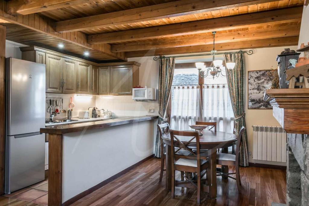 a kitchen with a table and a refrigerator at Casa Marimanha by SeaMount Rentals in Salardú