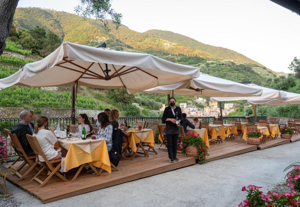 a group of people sitting at tables under umbrellas at Agriturismo Buranco in Monterosso al Mare