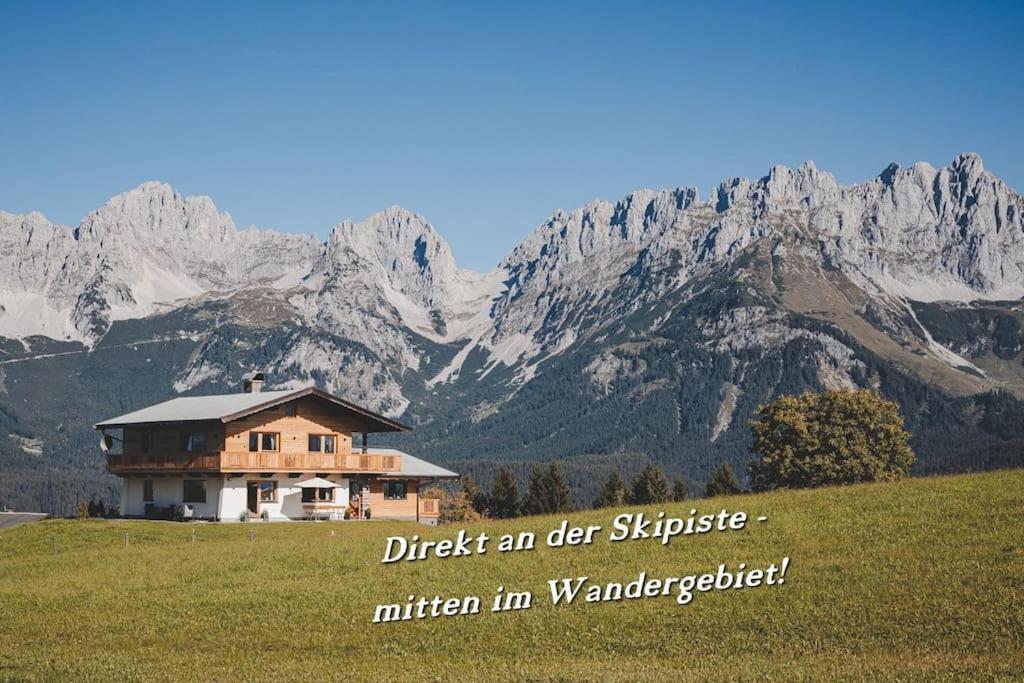 a house in a field with mountains in the background at Apartment zu Hollenau in Going