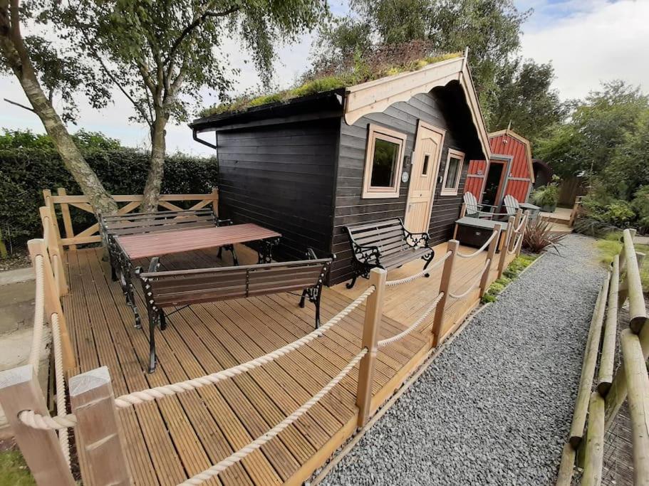 a cabin with a bench and a table on a deck at Seaways glamping, Silverbirch in Great Driffield