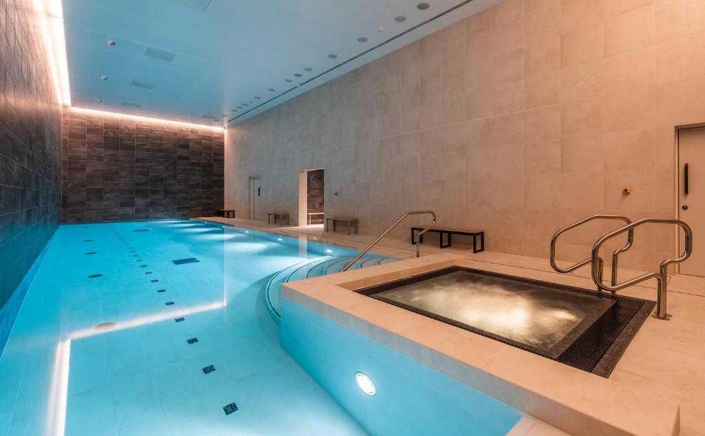 una gran piscina con bañera de hidromasaje en una habitación en CitySuites 2 Aparthotel en Mánchester