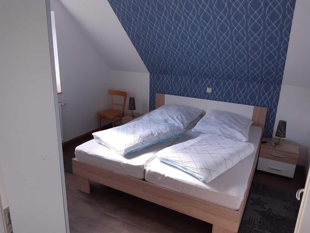 una camera con un letto con una parete blu di Helgas Ferienwohnung 4 Sterne a Südbrookmerland
