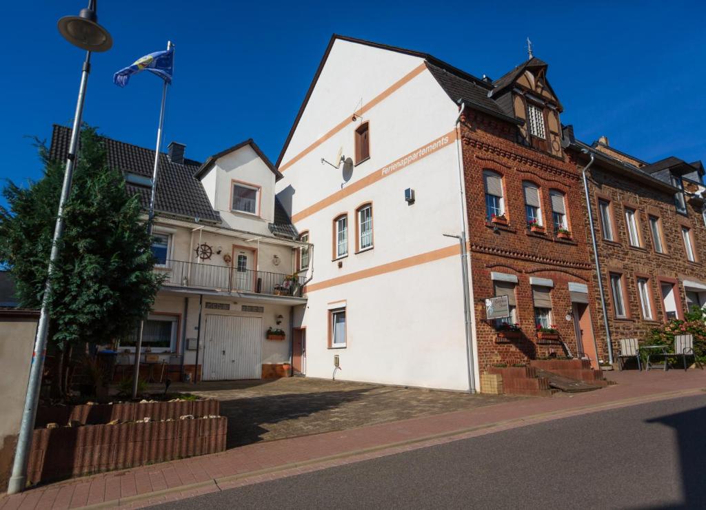 a white building next to a brick building at Gästehaus Steuer in Kröv