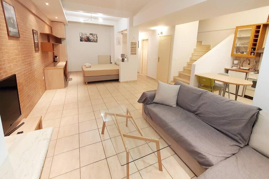 ein großes Wohnzimmer mit einem Sofa und einer Küche in der Unterkunft Xtina Studio in Athen