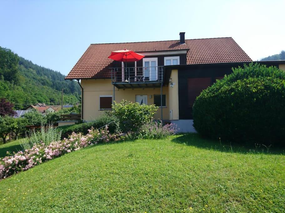 a house with a balcony with a red umbrella at Ferienwohnung Lahr im Schwarzwald ,120 qm, sehr ruhig, nahe Europa Park Rust in Lahr