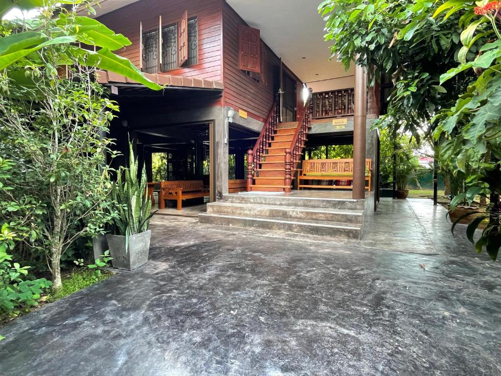 a house with a staircase in front of it at HomeandHomestay Chiang Kham in Chiang Kham