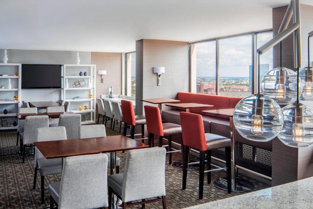 a restaurant with tables and chairs and windows at Sheraton Philadelphia University City Hotel in Philadelphia