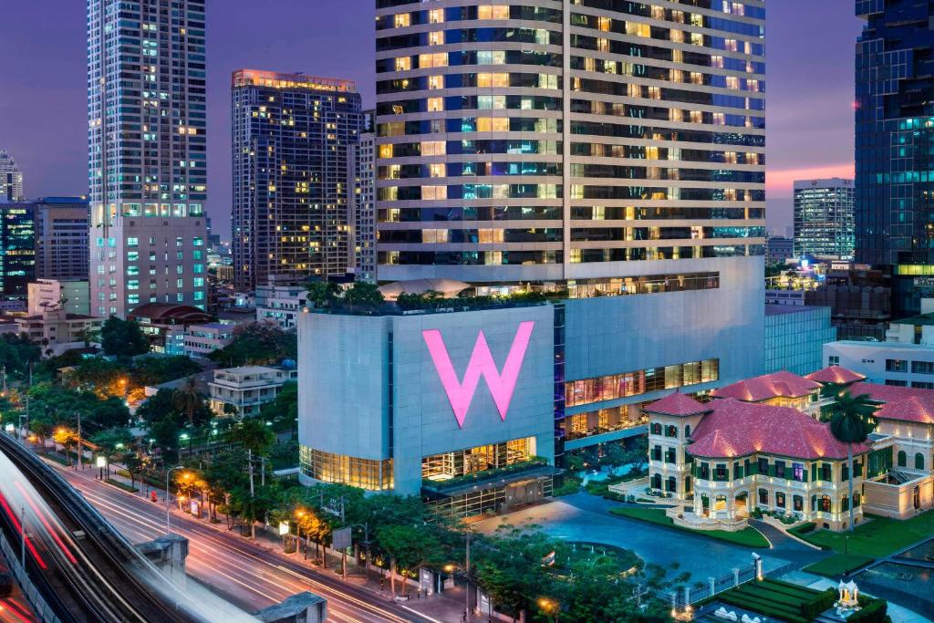 a large building with the letter w on it in a city at W Bangkok Hotel in Bangkok