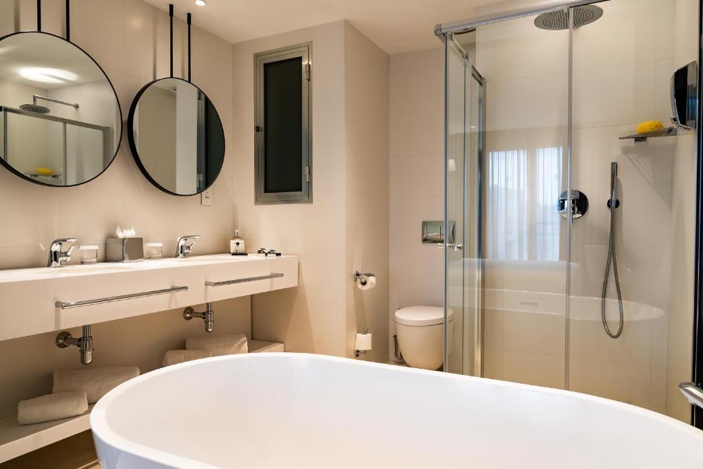 a bathroom with a white tub and a shower at Hotel Valentina in St. Julianʼs