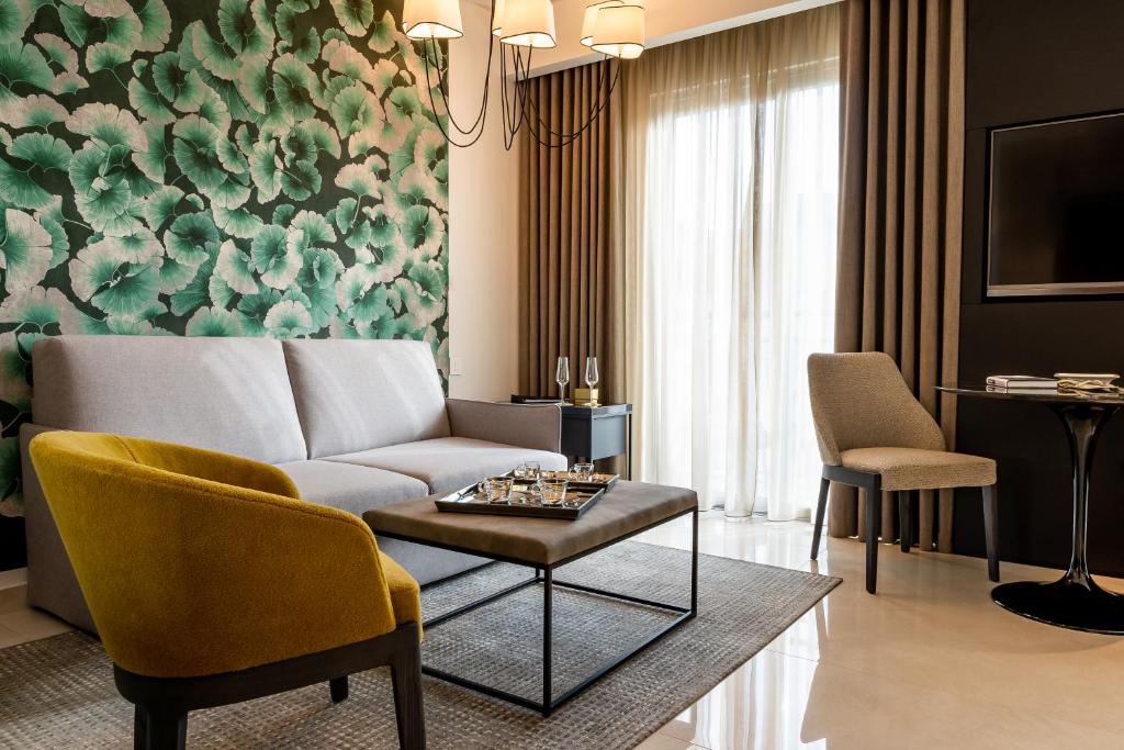 a living room with a couch and a table and chairs at Hotel Valentina in St. Julianʼs