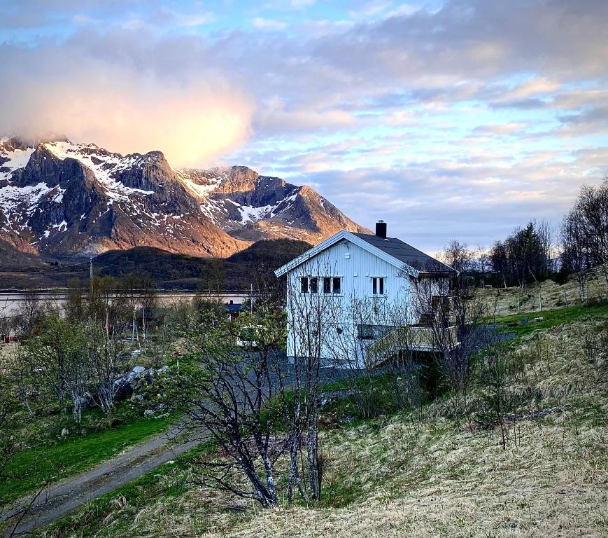 una casa blanca en una colina con montañas en el fondo en Wilderness House, en Urda