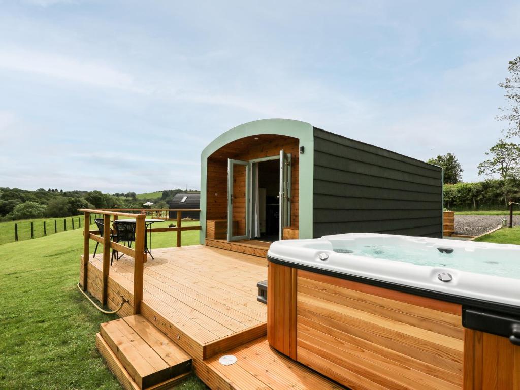 a hot tub on a deck in a backyard at Hwyl in Llandrindod Wells