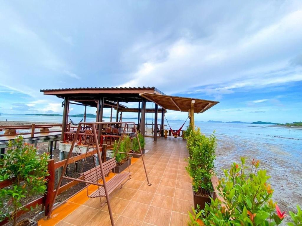 een restaurant op het strand met de oceaan op de achtergrond bij Baan Purada in Koh Lanta