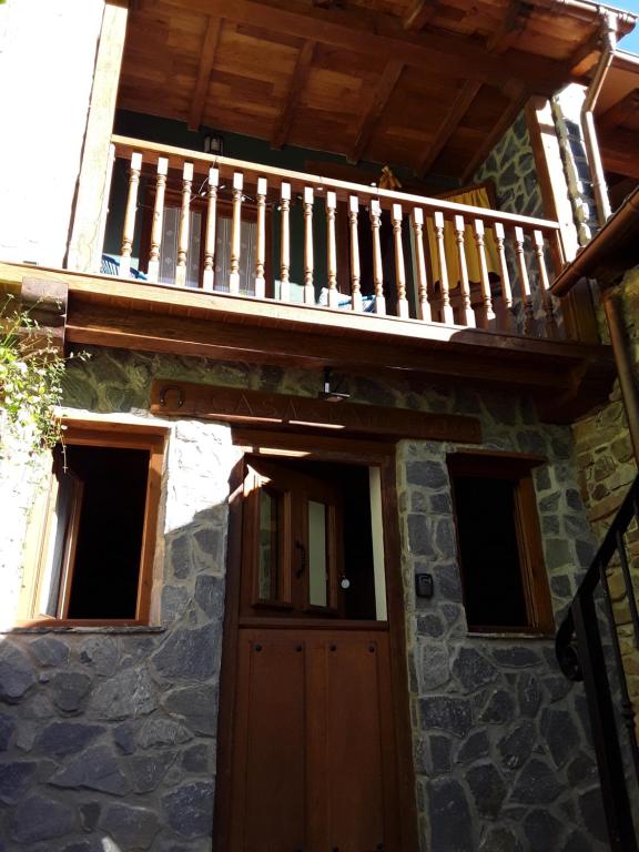 a house with a wooden door and a balcony at Casa Marcelo in Proaza