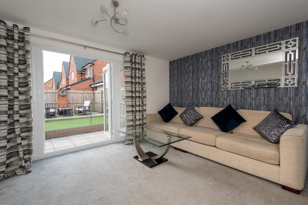 a living room with a couch and a large window at Tudhoe View in Spennymoor