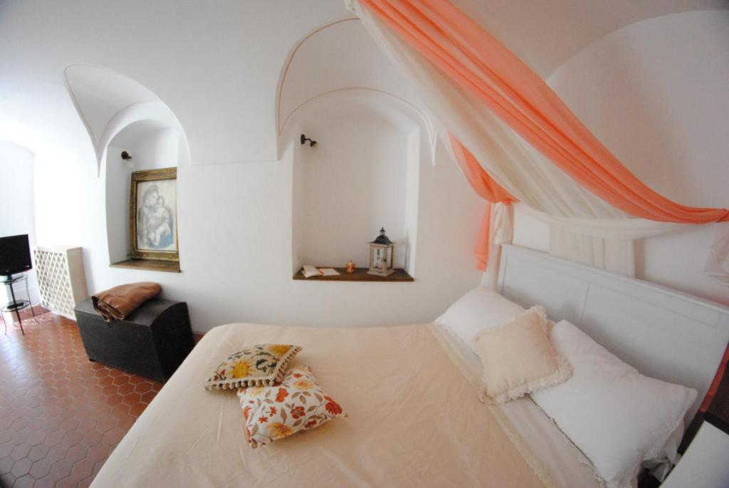 ein Schlafzimmer mit einem weißen Bett mit Kissen darauf in der Unterkunft B&B Le Gemme in Dolceacqua