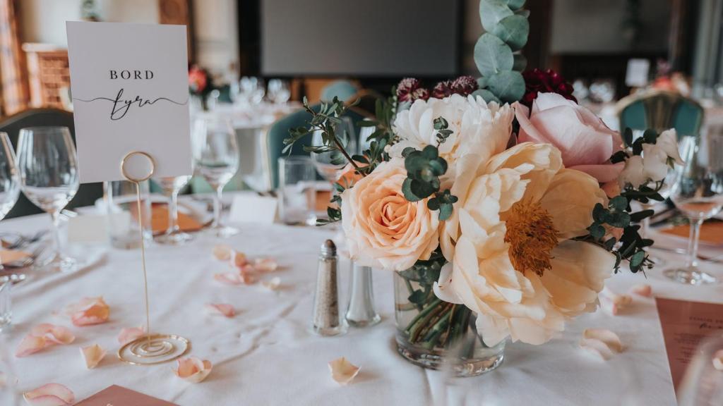 a vase filled with flowers sitting on a table at Hotel Hasselbacken in Stockholm