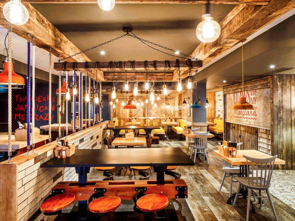 a restaurant with tables and chairs in a room at ibis Styles Manchester Portland in Manchester