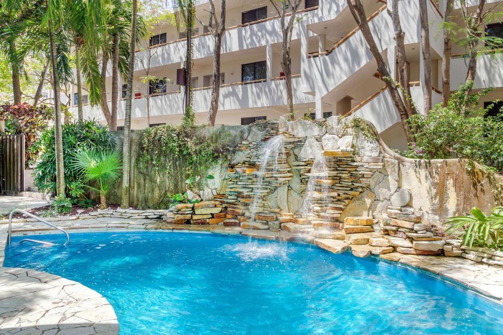 a swimming pool with a waterfall in front of a building at Comfort Inn Tampico in Tampico