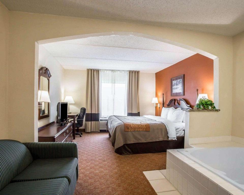 a hotel room with a bed and a bath tub at Comfort Inn & Suites Spartanburg North in Spartanburg
