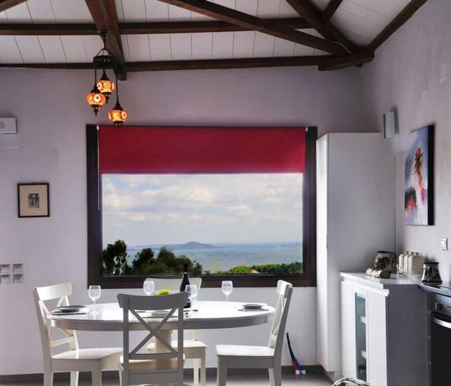 a dining room with a table and a large window at Magnolia Apartment in Alonnisos