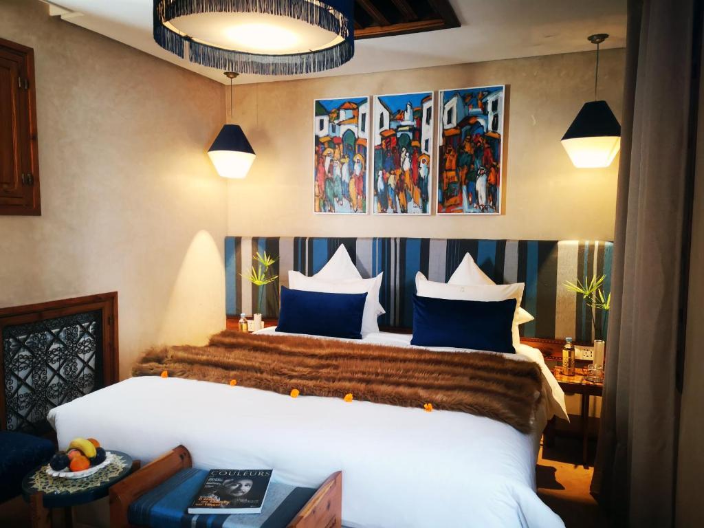 a bedroom with a bed with blue and white pillows at Riad Kalaa in Rabat