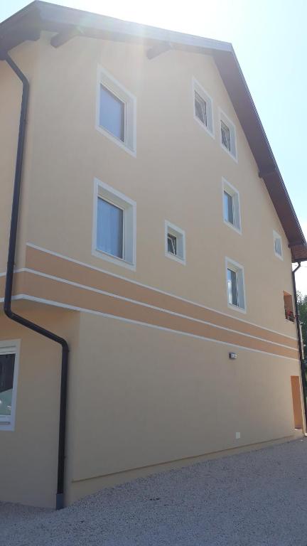 um edifício branco com janelas do lado em Vila Gajović em Pale