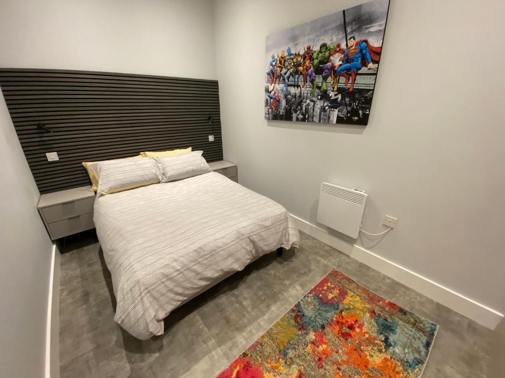 a bedroom with a bed and a painting on the wall at Kempston Suites Liverpool Apartment 7 in Liverpool