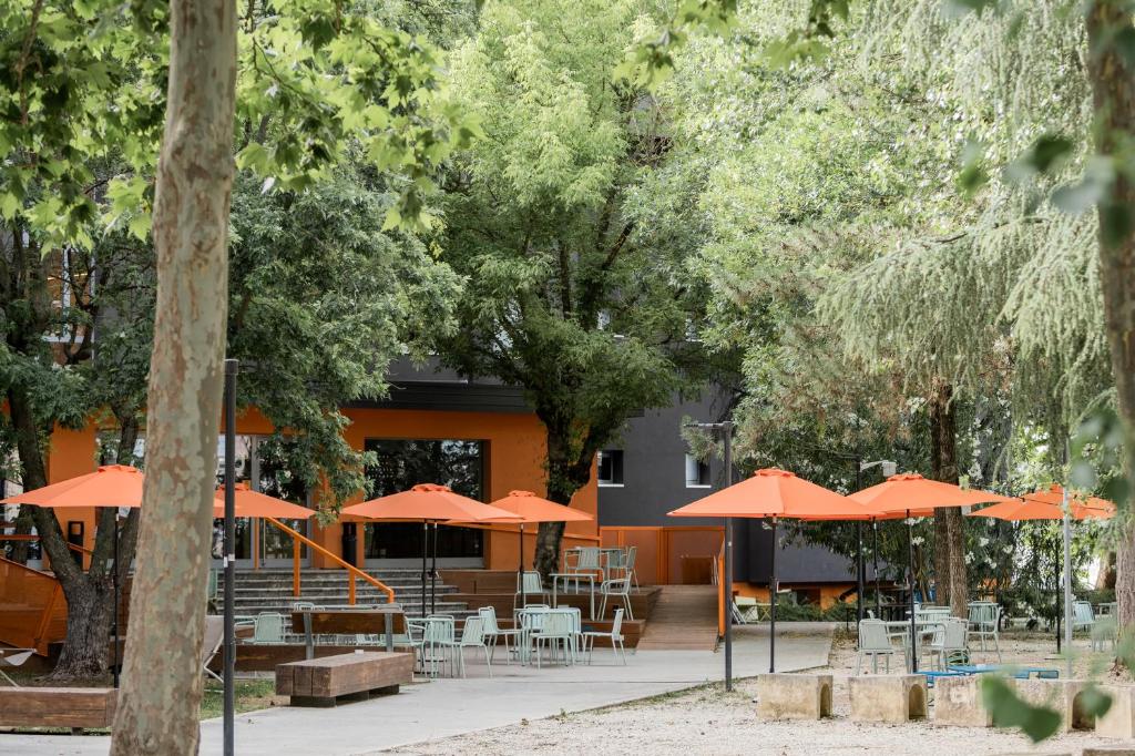 un edificio con sombrillas naranjas, mesas y sillas en Combo Bologna en Bolonia